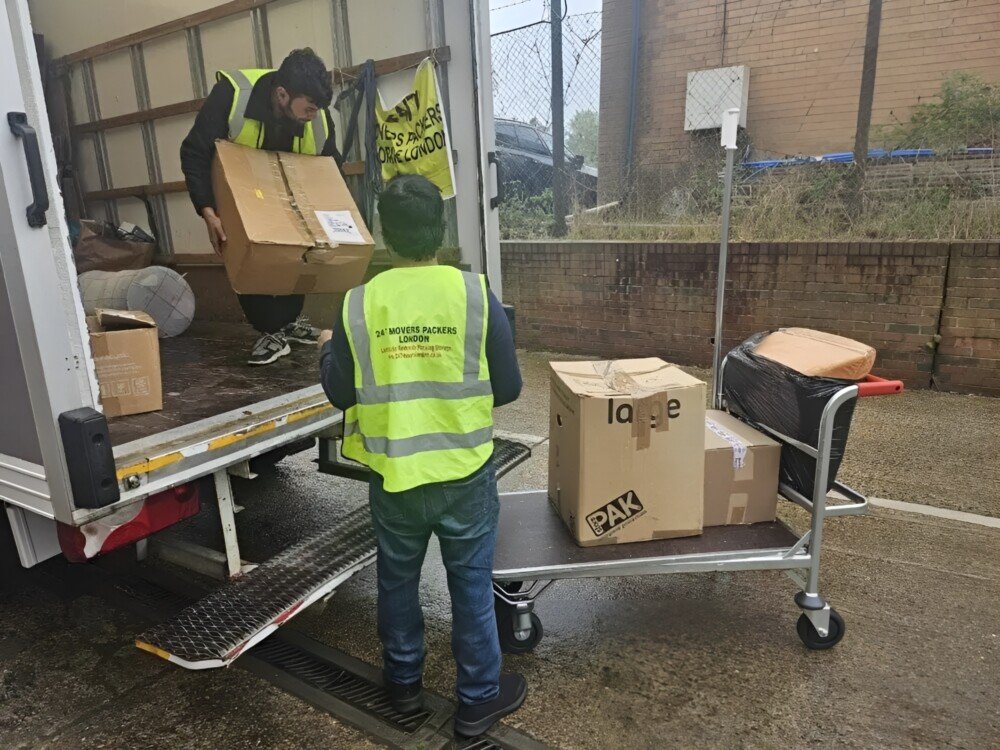 Two man are unloadingMaking Your Moves Memorable with our Top Notch Services the boxes from the truck in the trolley