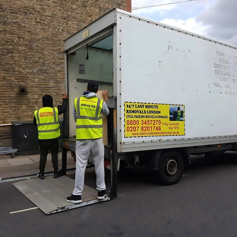 two workers of 24/7 Movers Packers London are loading the packed boxes into their professional van